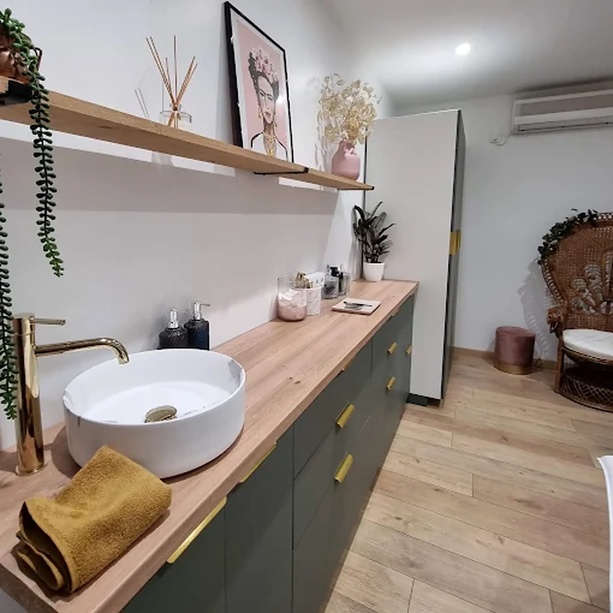 Espace soins de l’institut : plan de travail en bois clair et décoration végétale.