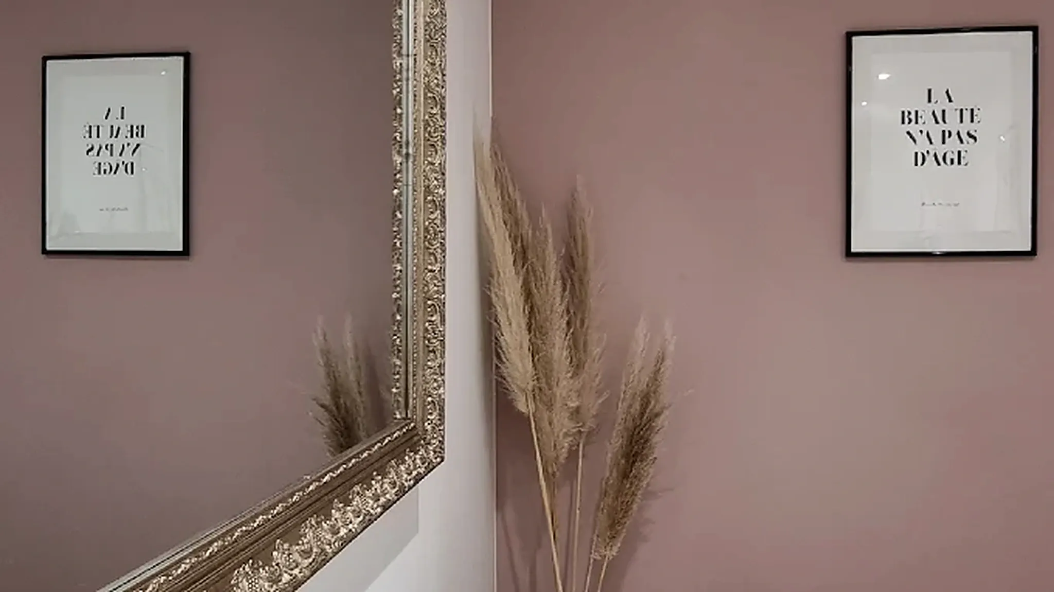 Détail de décoration de l’institut : miroir rond, feuillage séché et objets en rotin.